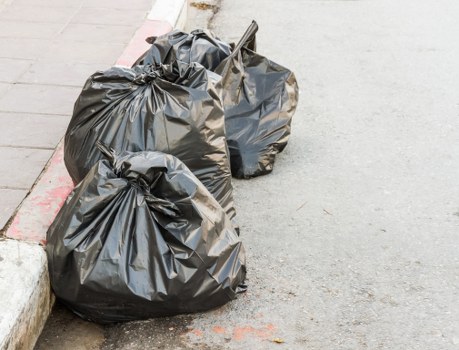 Construction site with builders clearing waste in Seven Kings